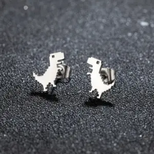 Zwei Ohrstecker in Form eines Pixel-Dinosauriers in Silber auf dunklem Untergrund