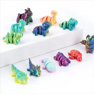 Bunte bewegliche Mini-Drachen und Tierfiguren auf weißem Podest