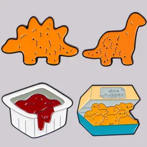 Vier orange und weiße Anstecknadeln: Dino-Nuggets und Soßenbecher