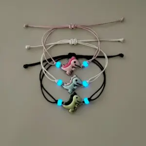 Verstellbare Armbänder mit Dinosaurier-Anhängern und Leuchtperlen in Rosa, Blau und Grün