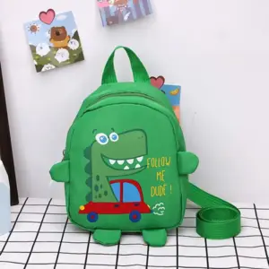 Grüner Kinderrucksack mit Dino-Motiv und rotem Auto, auf einem Tisch